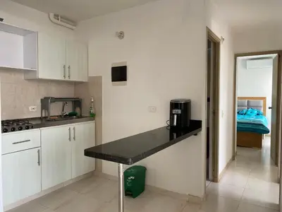 a kitchen with white cabinets and a black counter top at Amoblado cerca playa Marbella in Cartagena de Indias