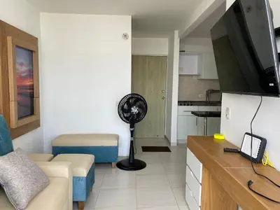 a living room with a couch a fan and a kitchen at Amoblado cerca playa Marbella in Cartagena de Indias