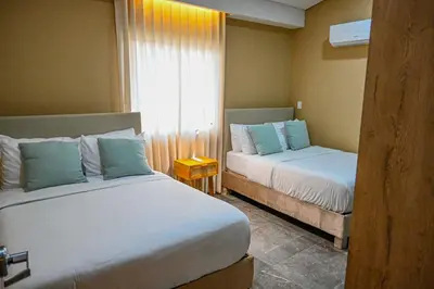 a hotel room with two beds and a window at Hotel Bahía Azul Manga Cartagena in Cartagena de Indias