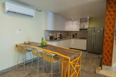 a kitchen with a wooden table with chairs and a refrigerator at Hotel Bahía Azul Manga Cartagena in Cartagena de Indias