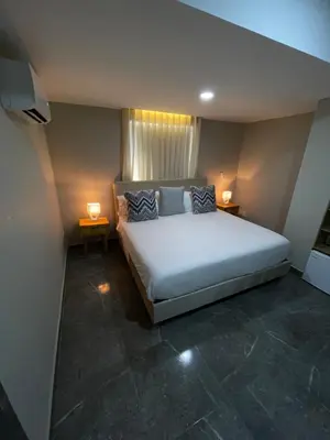 a bedroom with a large bed and two lamps at Hotel Bahía Azul Manga Cartagena in Cartagena de Indias
