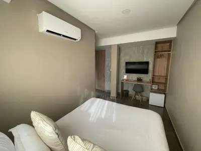 a bedroom with a white bed and a tv at Hotel Bahía Azul Manga Cartagena in Cartagena de Indias