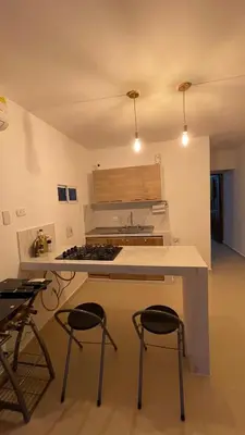 a kitchen with a counter and stools in a room at Holtalia in Santiago