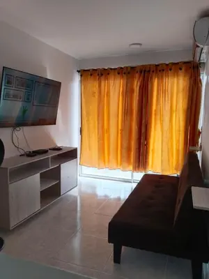 a living room with a couch and a large window at EntreLagos Family Suite Vista a la Ciudad in Cartagena de Indias