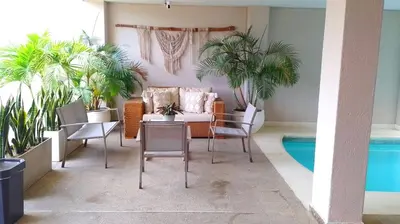 a living room with a couch and chairs and a pool at Bello Horizonte y CC ZAZUE in Santa Marta