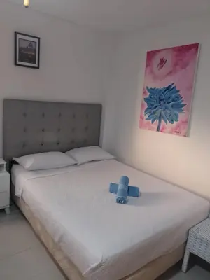 a bed with a blue teddy bear sitting on it at Bello Horizonte y CC ZAZUE in Santa Marta