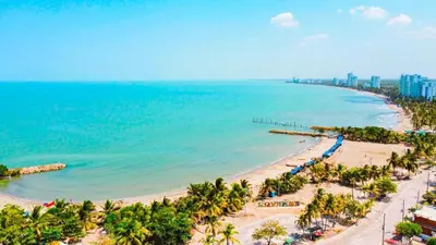 an aerial view of a beach with palm trees and the ocean at Escapada Perfecta en Apartasuites Privadas Coveñas in Coveñas
