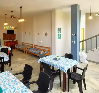 a dining room with tables and chairs and a staircase at Escapada Perfecta en Apartasuites Privadas Coveñas in Coveñas