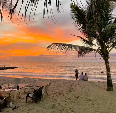 a beach with chairs and a palm tree and the ocean at Escapada Perfecta en Apartasuites Privadas Coveñas in Coveñas