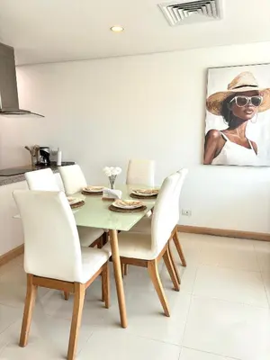 a dining room with a green table and white chairs at Apartamento entero amoblado con excelente ubicación en Barranquilla in Barranquilla