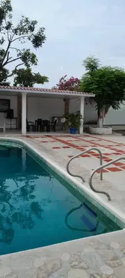 a swimming pool in front of a house at Villa Roy in Santa Marta