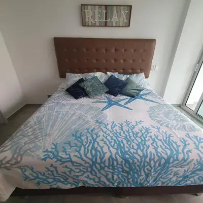 a bedroom with a bed with a blue and white comforter at Luxurious, modern apartment in Cartagena Morros 3 in Cartagena de Indias