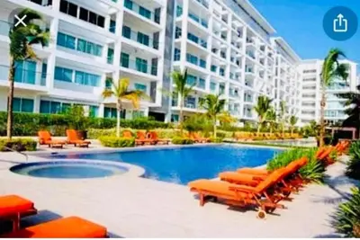 a hotel with a swimming pool with chairs and a building at Luxurious, modern apartment in Cartagena Morros 3 in Cartagena de Indias