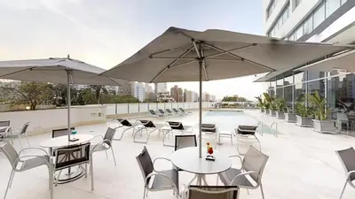 a patio with tables and chairs and umbrellas at Aparthotel Suite Hotel Estelar 1608 in Barranquilla