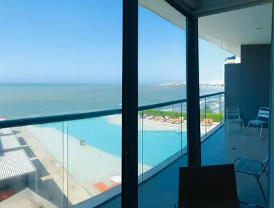 a balcony with a view of a swimming pool and the ocean at Luxurious and modern oceanfront apartment with views of the historic city 2B and 2BR in Cartagena de Indias
