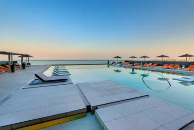 a large swimming pool with chairs and umbrellas at Luxurious and modern oceanfront apartment with views of the historic city 2B and 2BR in Cartagena de Indias