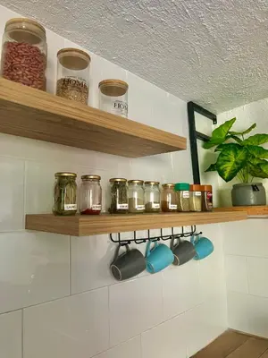 a kitchen with wooden shelves with jars and plants at Casa Agarj in Santa Marta