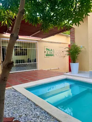 a swimming pool in a yard with a tree at Casa Agarj in Santa Marta