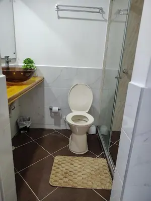 a bathroom with a toilet and a glass shower at Acojedor apto en coveñas in Coveñas