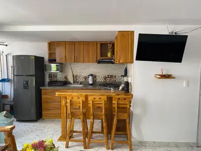 a kitchen with wooden tables and a refrigerator at Acojedor apto en coveñas in Coveñas