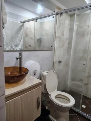 a bathroom with a toilet and a glass shower at Acojedor apto en coveñas in Coveñas