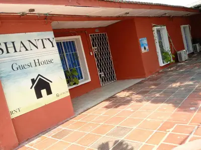 a red house with a sign for a guest house at Shantyhostal in Cartagena de Indias