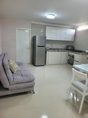 a living room with a couch and a refrigerator at Aparta estudio Malecón del Río in Barranquilla