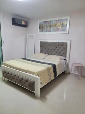 a bed in a white room with a bed frame at Aparta estudio Malecón del Río in Barranquilla