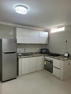a kitchen with a stainless steel refrigerator and cabinets at Aparta estudio Malecón del Río in Barranquilla