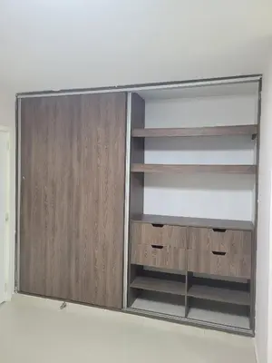 an empty closet with wooden doors and shelves at Aparta estudio Malecón del Río in Barranquilla