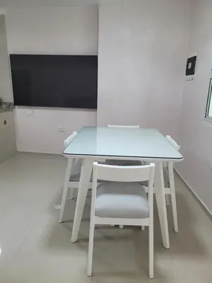 a white table with a white chair and a tv at Aparta estudio Malecón del Río in Barranquilla