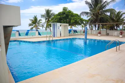 a large swimming pool with blue water and palm trees at Magico Apartamento Frente al Mar 2 Habitaciones B11B in Coveñitas