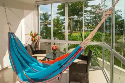a hammock in a room with a table and windows at Magico Apartamento Frente al Mar 2 Habitaciones B11B in Coveñitas