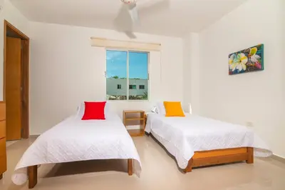two beds in a white room with a window at Magico Apartamento Frente al Mar 2 Habitaciones B11B in Coveñitas