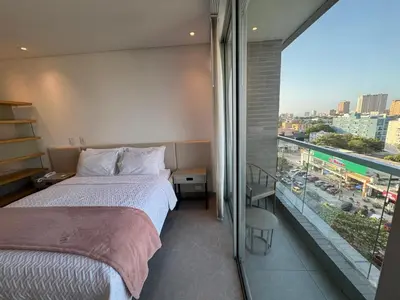 a hotel room with two beds and a large window at Hermosa y Comoda Suite en Distrito 90 in Barranquilla