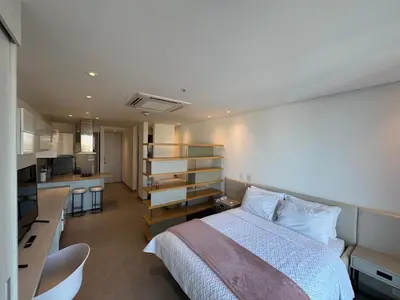 a bedroom with a large bed and a kitchen at Hermosa y Comoda Suite en Distrito 90 in Barranquilla