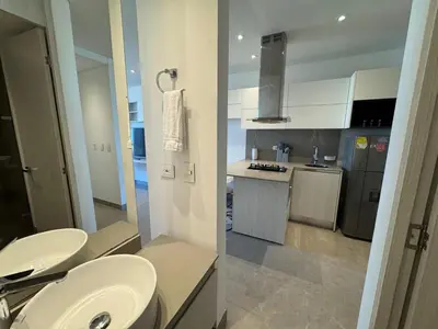 a bathroom with two sinks and a kitchen at Hermosa y Comoda Suite en Distrito 90 in Barranquilla