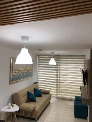 a living room with a couch and a table at Comfortable 2 bedroom apartment with pool in Miramar in Barranquilla