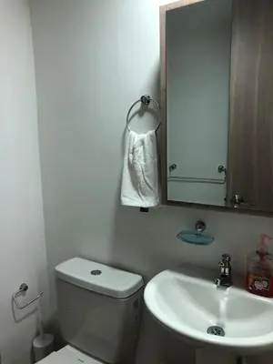 a bathroom with a toilet and a sink and a mirror at Comfortable 2 bedroom apartment with pool in Miramar in Barranquilla