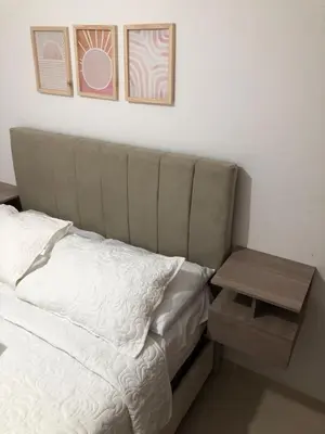 a bedroom with a bed and a side table at Comfortable 2 bedroom apartment with pool in Miramar in Barranquilla