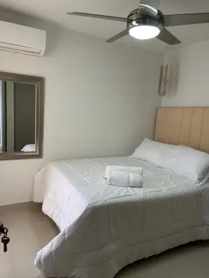 a bedroom with a white bed with a ceiling fan at Apartamento en Torices in Cartagena de Indias