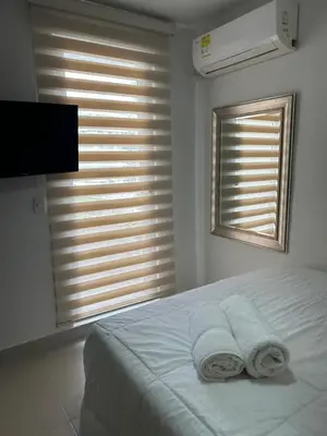 a white bedroom with two towels on a bed at Apartamento en Torices in Cartagena de Indias