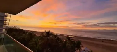 a view of the beach at sunset from a condo at Apartamento en Cartagena con vista al mar in Cartagena de Indias