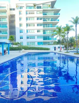 a swimming pool in front of a large building at Apartamento en Cartagena con vista al mar in Cartagena de Indias