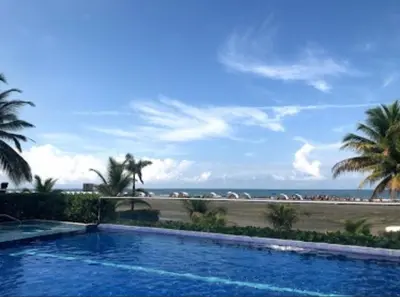 a swimming pool with the beach in the background at Apartamento vista al mar cartagena Edificio Morros in Cartagena de Indias