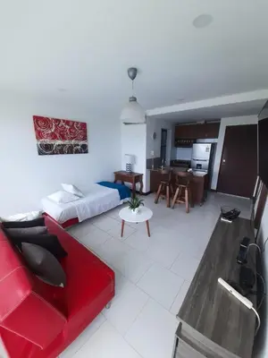 a living room with a red couch and a kitchen at Apartamento vista al mar cartagena Edificio Morros in Cartagena de Indias