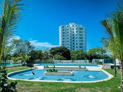 a large swimming pool with a tall building in the background at Moderno, vista al mar, AC, Wifi200MB,5Min Aeropuerto in Estación El Salto