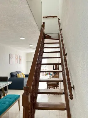 a wooden staircase leading up to a living room at Beautiful duplex in the historic center! in Cartagena de Indias