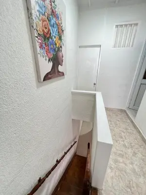 a white staircase with a painting on the wall at Beautiful duplex in the historic center! in Cartagena de Indias
