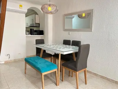 a dining room table with four chairs and a blue seat at Beautiful duplex in the historic center! in Cartagena de Indias
